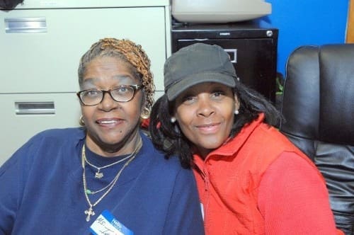 Two smiling women posing.